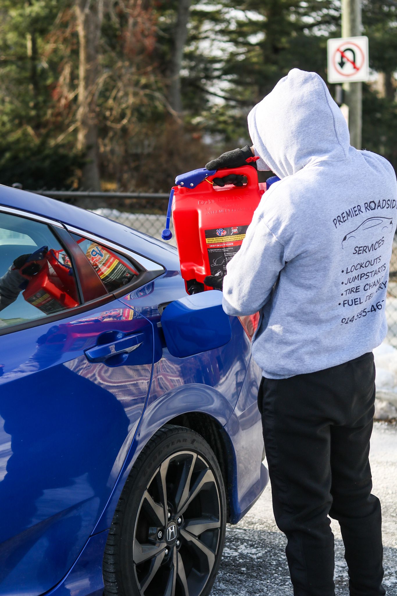 "Man delivering fuel to a vehicle for roadside assistance."