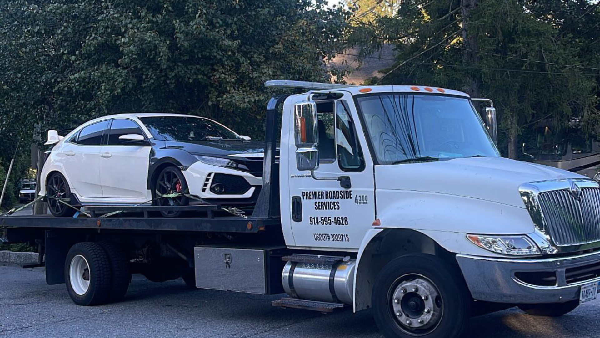 Tow truck transporting a car on its platform."